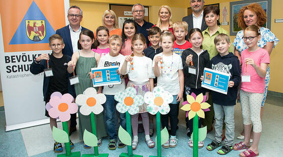 Gruppenbild bei der Präsentation der Initiative „Gefahren erkennen und vermeiden“ mit (stehend hinten v.l.) Mag. Franz Bock, Schulqualitätsmanager, Bildungsdirektion Burgenland, Dipl. Päd. VDir. OSR Eva Scheibstock, Präsident des Bevölkerungsschutz Mag. Herbert Wagner, MSc, MBA, Landesrätin Mag. (FH) Daniela Winkler, Landesrat Mag. Heinrich Dorner, Rosemarie Harter, Gemeindevorständin,Vizebürgermeisterin Mag. Monika Teubenbacher-Schriefl und Schüler*innen der Volksschule Müllendorf.