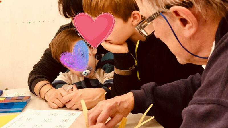 Kinder basteln gemeinsam mit älteren Menschen